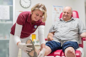 Wundversorgung – Ärztin untersucht Patient